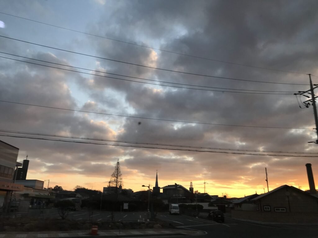 電車の窓から見た夜明けの空